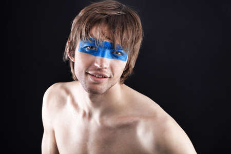 Shot of a stylish young man with painted eyes. の写真素材