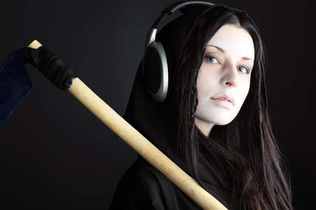 Woman death reaper over black background. Halloween.の写真素材