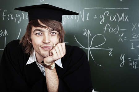 Educational theme: graduating student in academic gown in a classroom.の写真素材