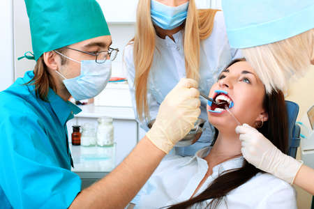 Shot of a young woman with dentists in a dental surgery. Healthcare, medicine.の写真素材