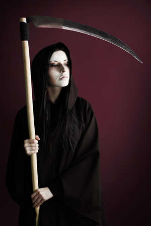 Woman death reaper over black background. Halloween.の写真素材