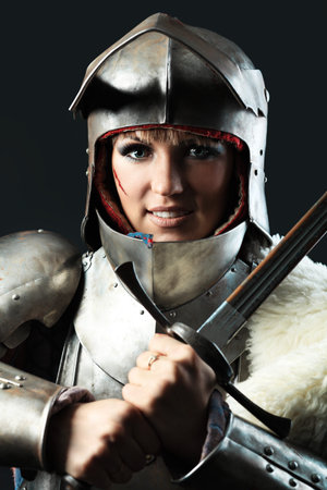 Portrait of a medieval female knight in armour over black background.