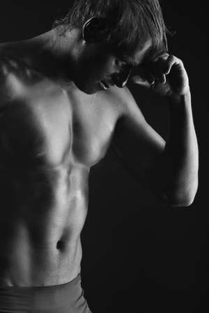 Portrait of a muscular man painted with black color. Body painting project.の写真素材