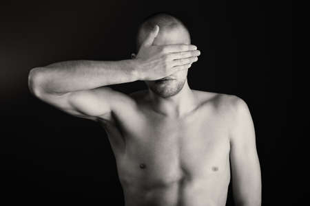 Portrait of a handsome muscular man posing over black background.の写真素材