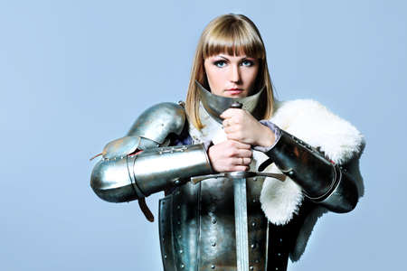 Portrait of a medieval female knight in armour over grey background.の写真素材