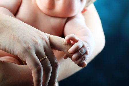 Baby is holding mother's hand.の写真素材