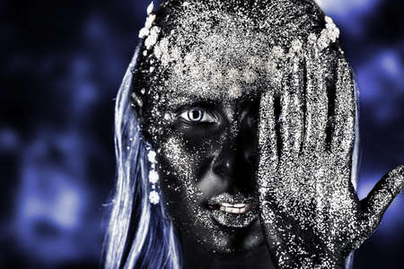 Portrait of an artistic woman painted with black color and spangled. Body painting project. Jewellery.の写真素材