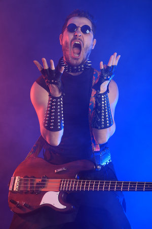 Heavy metal musician  is playing electrical guitar. Shot in a studio.