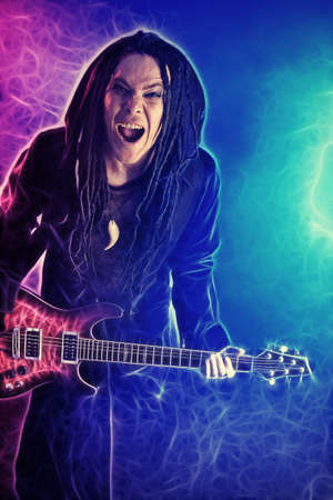 Heavy metal musician  is playing electrical guitar. Shot in a studio.の写真素材