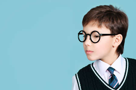 Educational theme: portrait of a schoolboy. Studio shot over grey background.の写真素材