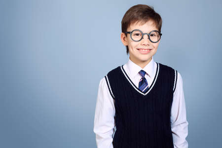 Educational theme: portrait of a schoolboy. Studio shot over grey background.の写真素材