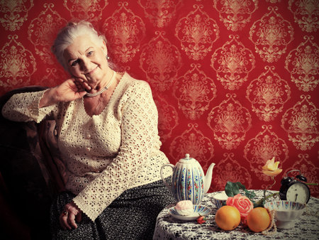 Portrait of a smiling senior woman having a rest at home. の写真素材