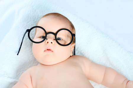 Beautiful baby in glasses. Shot in a studio. の写真素材