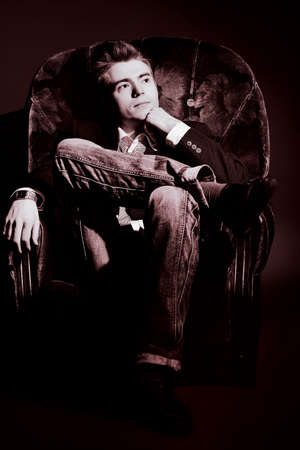 Portrait of a handsome young man posing over black background.の写真素材