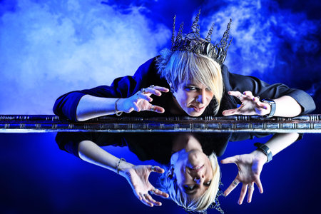 Portrait of an artistic young man in a king costume. Studio shot.