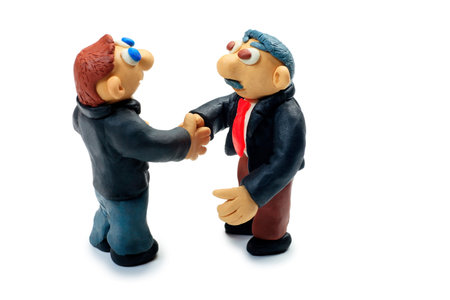Shot of two plasticine businessmen shaking their hands. Isolated over white background.