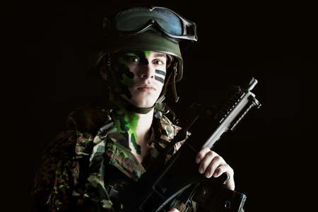 Shot of a conceptual soldier painted in khaki colors. Studio shot over black background.の写真素材