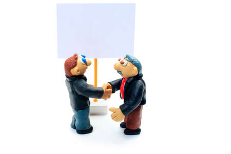 Shot of two plasticine businessmen shaking their hands. Isolated over white background.の写真素材