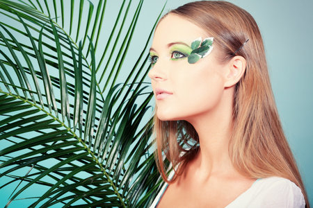 Portrait of a beautiful tanned woman  posing with flowers.の写真素材