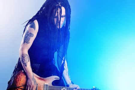 Heavy metal musician  is playing electrical guitar. Shot in a studio.の写真素材