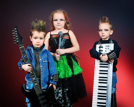 Group of children singing in heavy metal style. Shot in a studio.