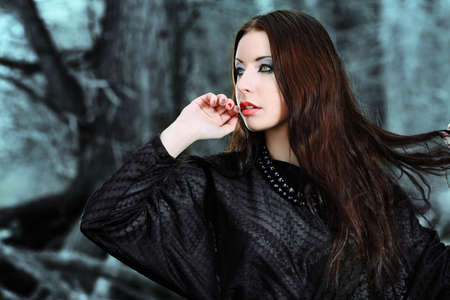 Shot of a gothic woman in a winter park. Fashion.の写真素材