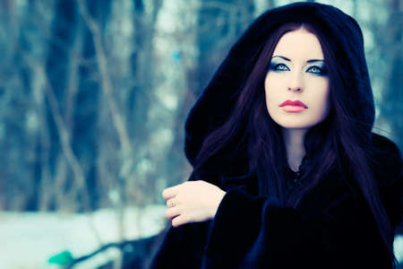 Shot of a gothic woman in a winter park. Fashion.の写真素材