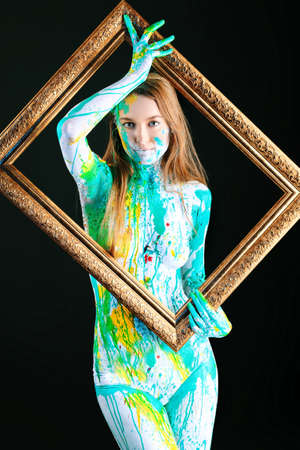 Art project: beautiful woman painted with many vivid colors. Over black background.の写真素材