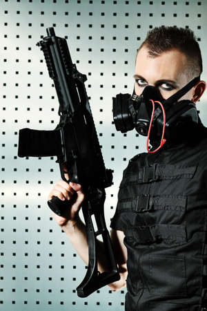 Shot of a conceptual man in a respirator holding a gun. の写真素材