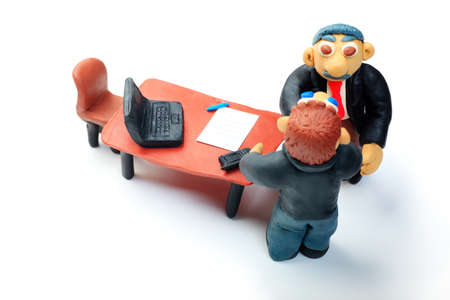 Shot of two plasticine businessmen shaking their hands in office. Isolated over white background.の写真素材