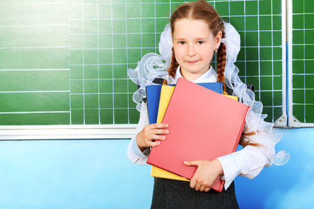 Portrait of a pretty schoolgirl in a classroom.