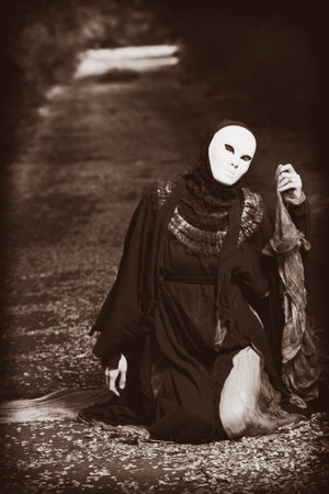 Shot of a woman in mask wearing old-fashioned dress. の写真素材