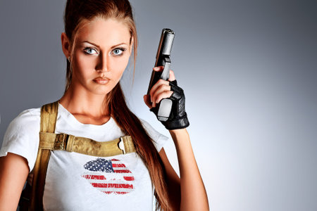 Shot of a sexy military woman posing with guns.