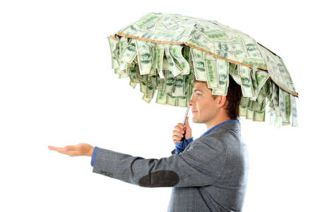 Business concept: businessman holding an umbrellar of money. Isolated over white. の写真素材