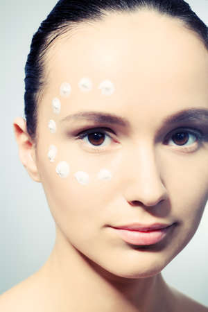 Portrait of beautiful spa girl with cream on her face.の写真素材