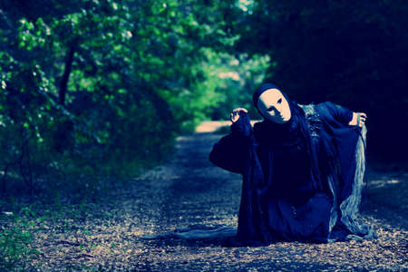 Shot of a woman in mask wearing old-fashioned dress. の写真素材