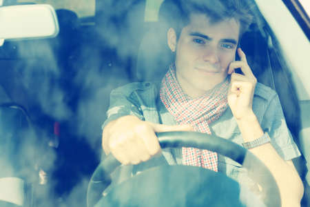 Handsome young man having summer trip on a car.の写真素材