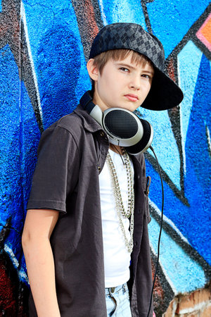 Portrait of a trendy boy teenager with headphones outdoors.