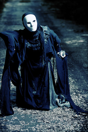Shot of a woman in mask wearing old-fashioned dress. 
