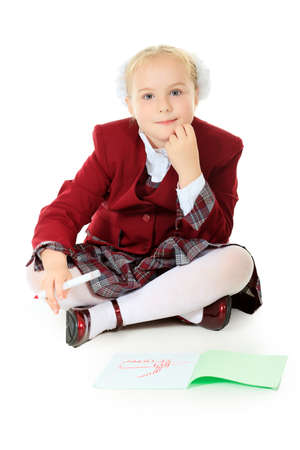 Portrait of a cute schoolgirl with pen and workbook. Isolated over white background.の写真素材