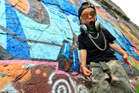 Portrait of a trendy little boy  with headphones outdoors.の写真素材