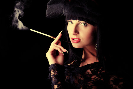 Shot of a sexy smoking woman in erotic lingerie over black background.