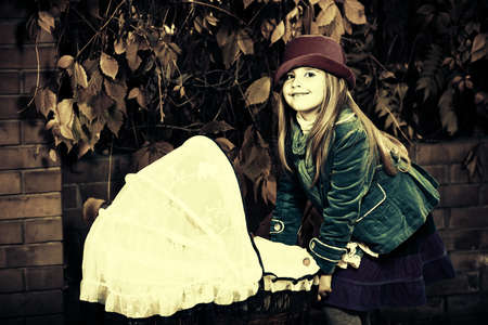 Shot of a cute girl walking with baby buggy at the park.の写真素材