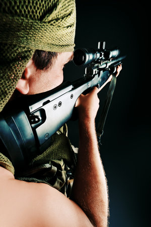 Shot of a conceptual soldier painted in khaki colors. Over black background.の写真素材