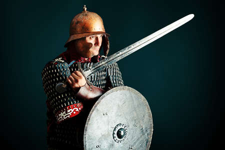 Portrait of a medieval male knight in armor over black background.の写真素材