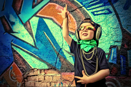 Portrait of a trendy little boy  with headphones outdoors.の写真素材