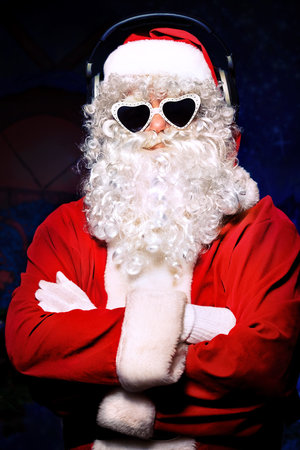 Santa Claus is listening to music in headphones. Christmas.