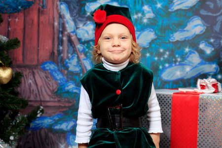 Little girl in Christmas elf costume posing over christmas background.の写真素材