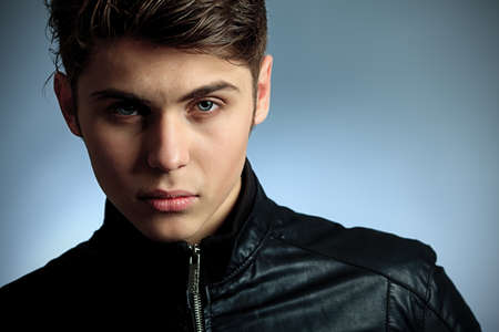 Studio shot of a handsome young man over gray background.の写真素材