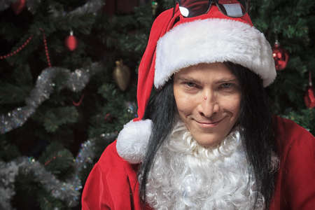 Portrait of a funny young man in Santa Claus hat and beard. Christmas.の写真素材